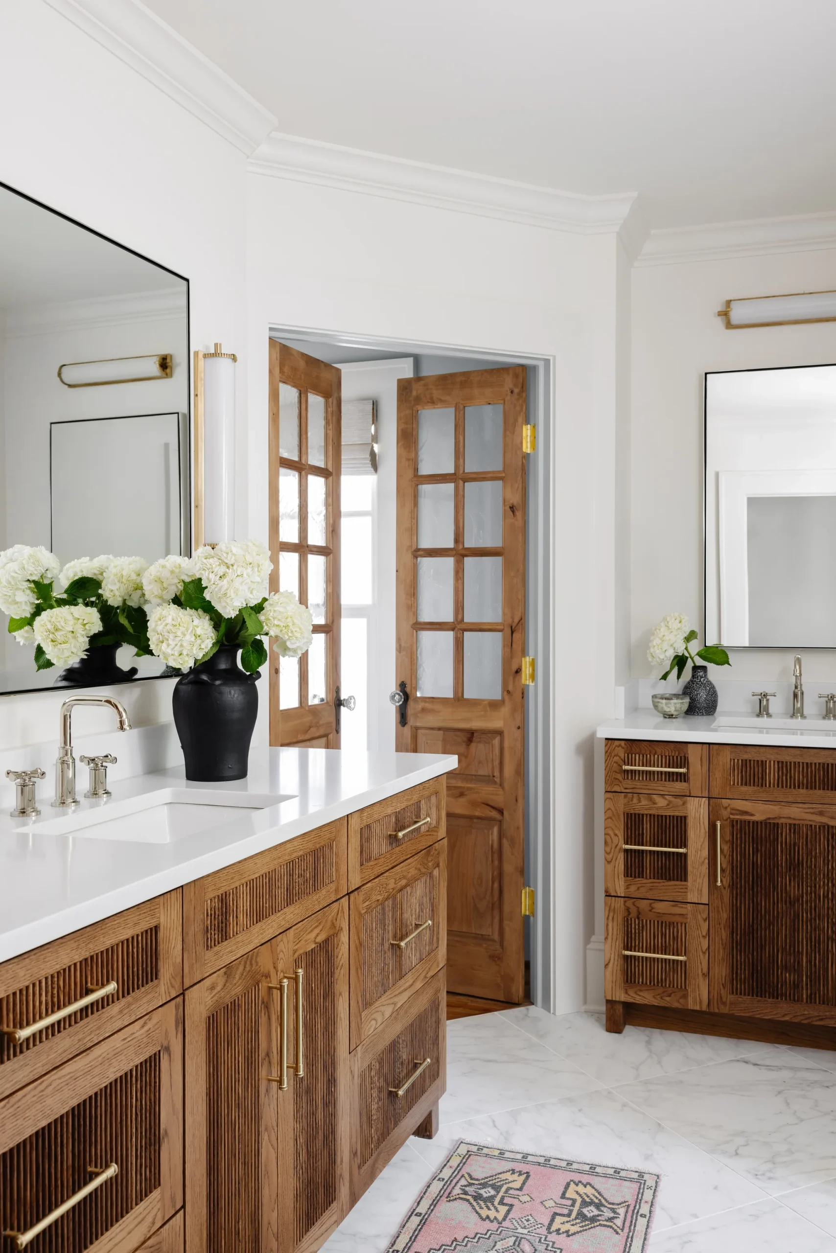 Bathroom remodel in Historic Dilworth, wood vanities, white countertops, and brass hardware