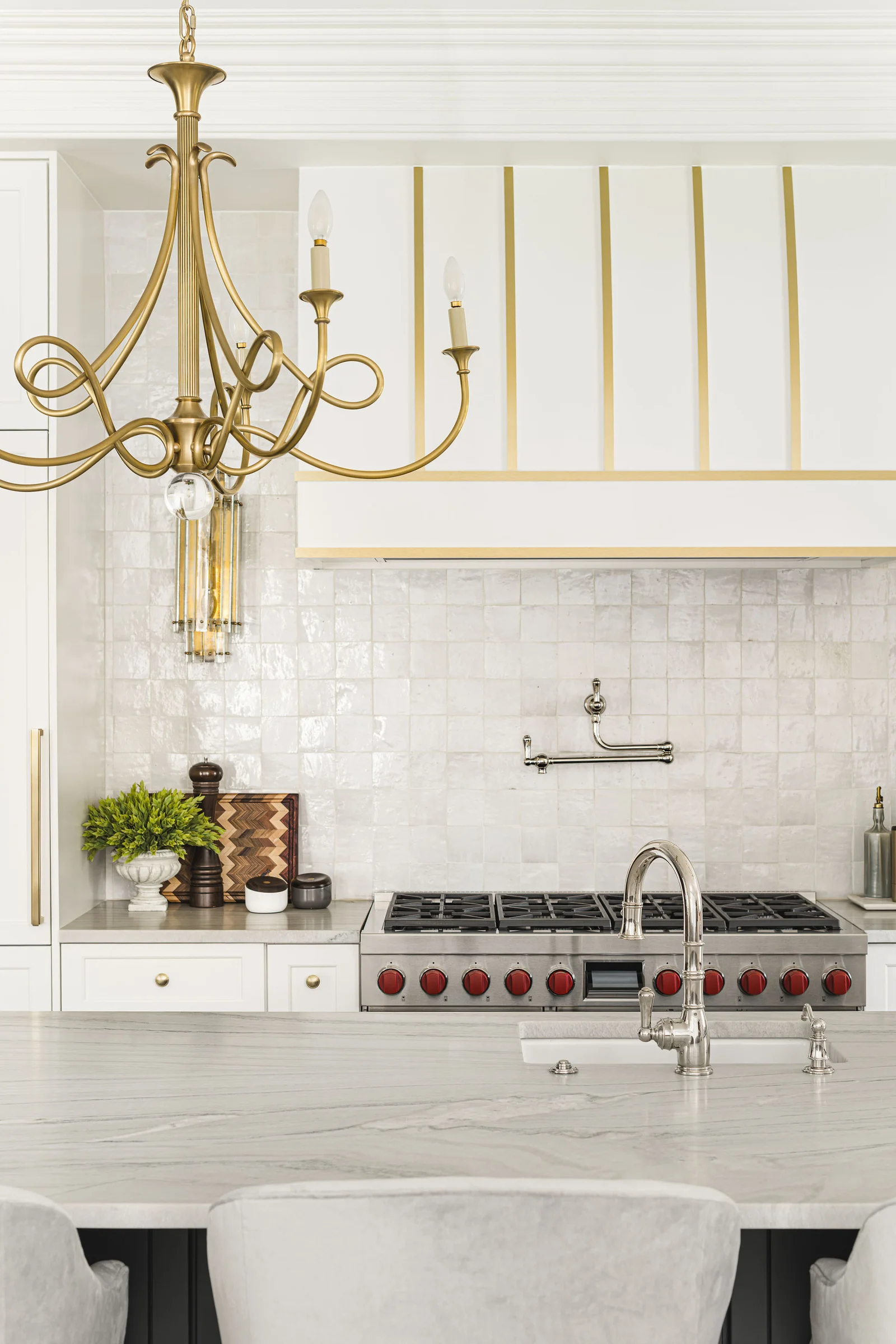 Kitchen remodel in Longview Country Club with a gold chandelier, white tile, and a stainless steel range