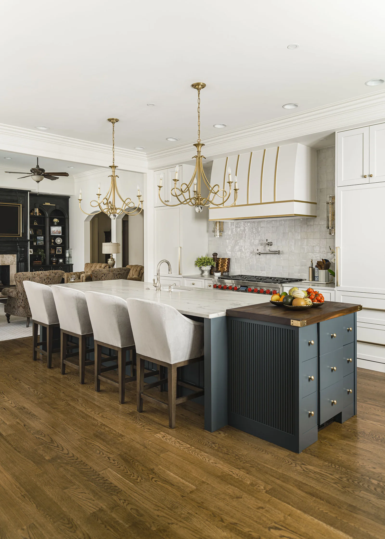 Kitchen remodel in Longview Country Club with a large island, white cabinets, and gold chandeliers