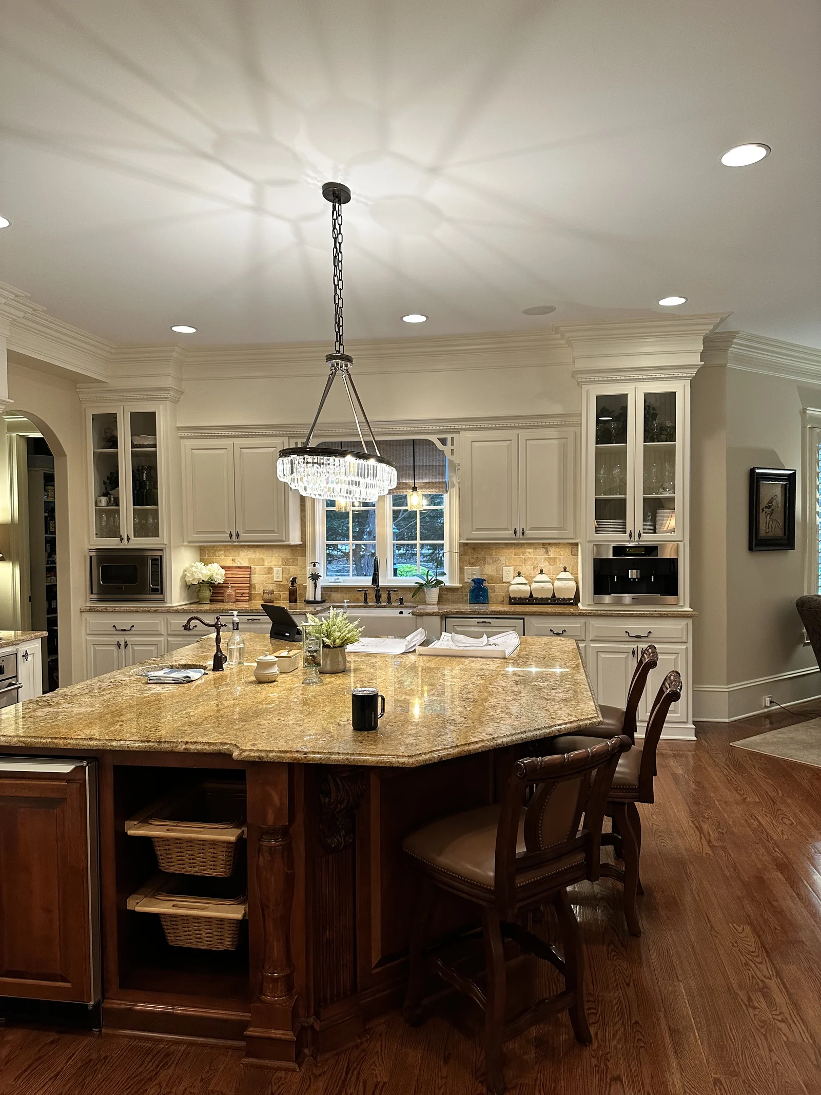 Before: Longview Country Club kitchen with cream cabinets, a dark wood island with a granite top, and wood floors