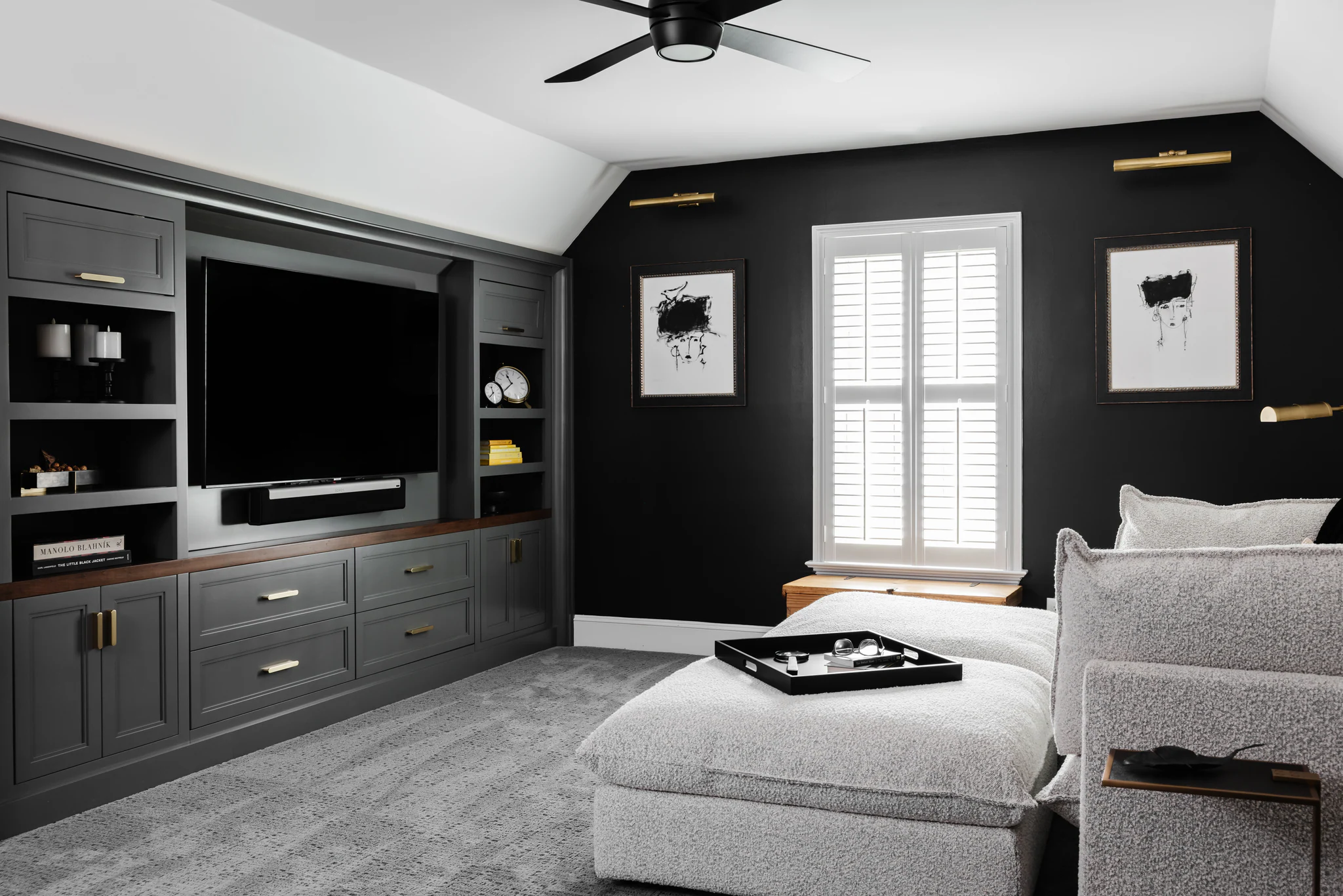 After: Quail Hollow media room with dark gray built-in cabinets, black walls, and a light sofa