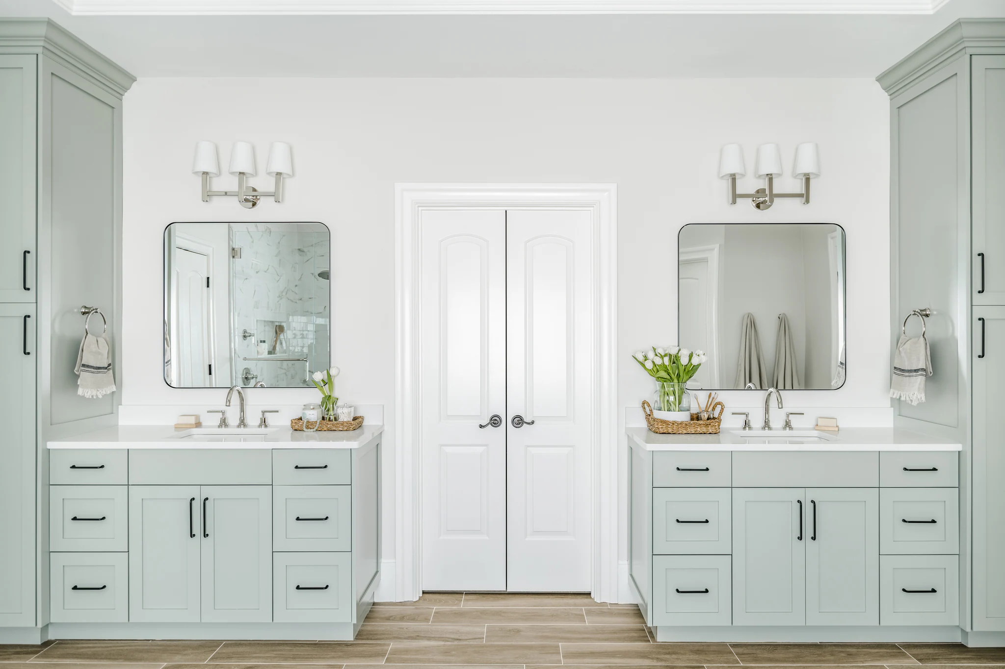 Ballantyne Country Club bathroom with dual vanities, light green cabinets, and white countertops