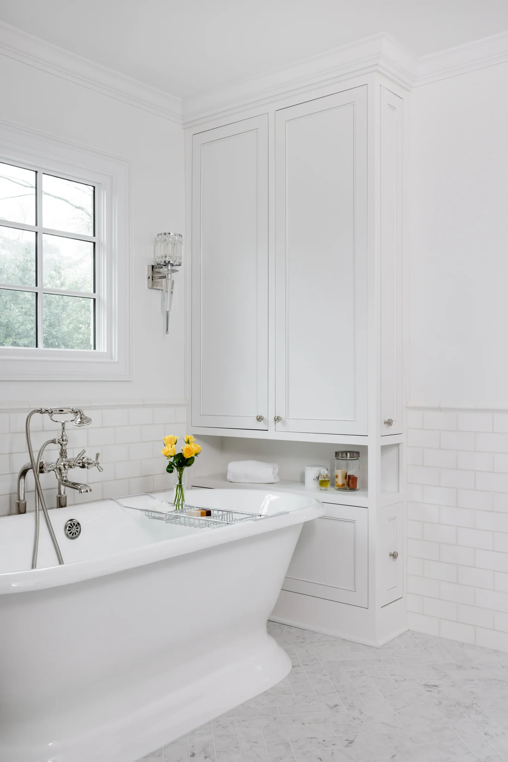 After: Quail Hollow bathroom with a freestanding tub, white built-in cabinetry, and subway tile
