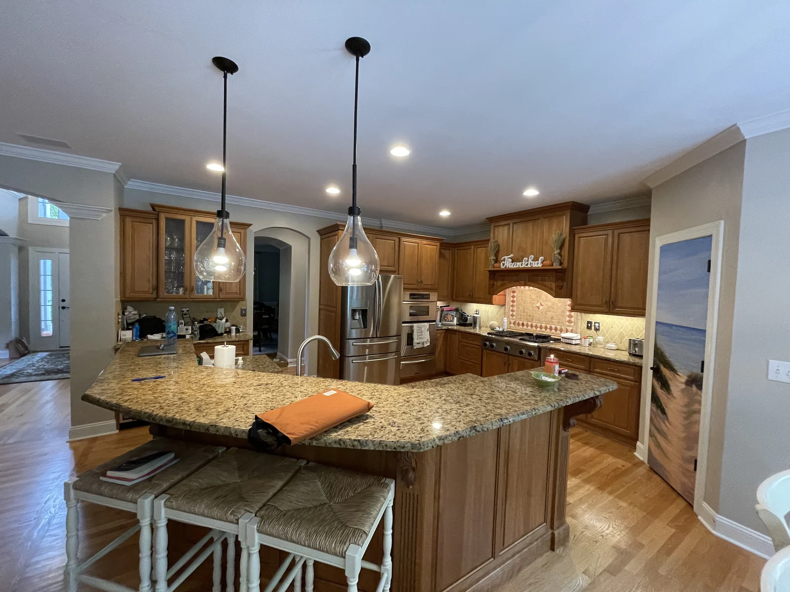 Before: Providence Plantation kitchen with light wood cabinets, a granite island, and stainless appliances