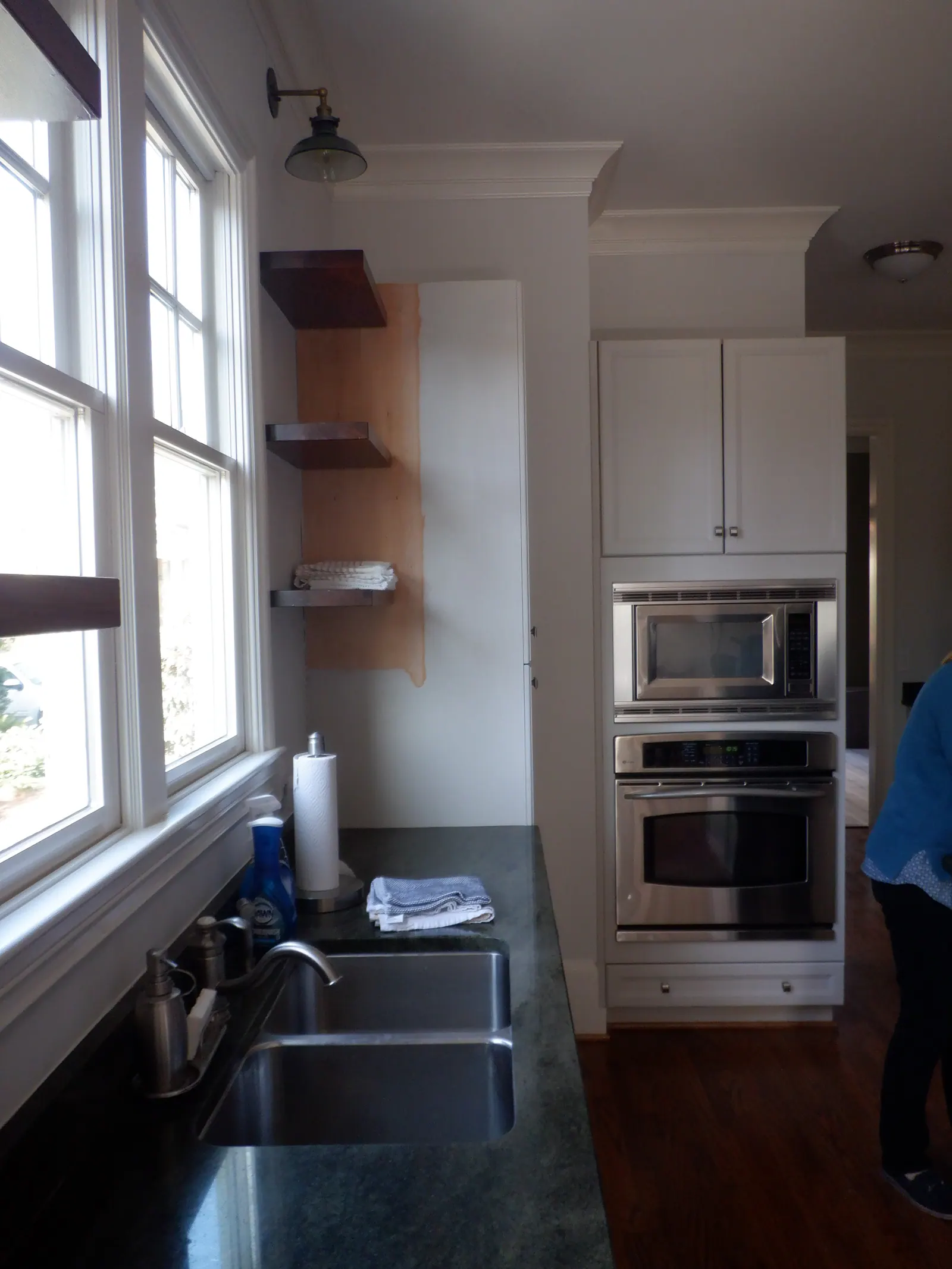 Kitchen remodel in Heydon Hall with dark green counters, stainless steel appliances, and open shelving
