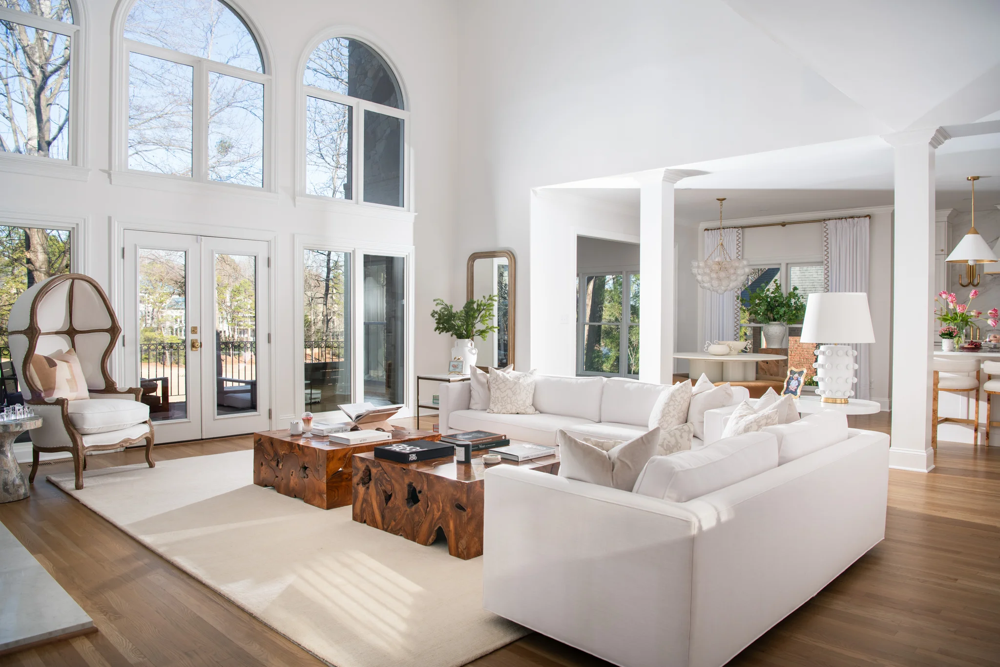 Living room in Ballantyne Country Club with white sofas, wood coffee tables, and arched windows