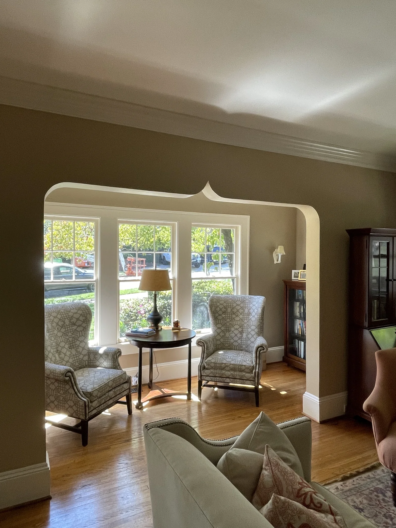 Living room in Historic Dilworth with an arched entry, two patterned wingback chairs, and wood floors