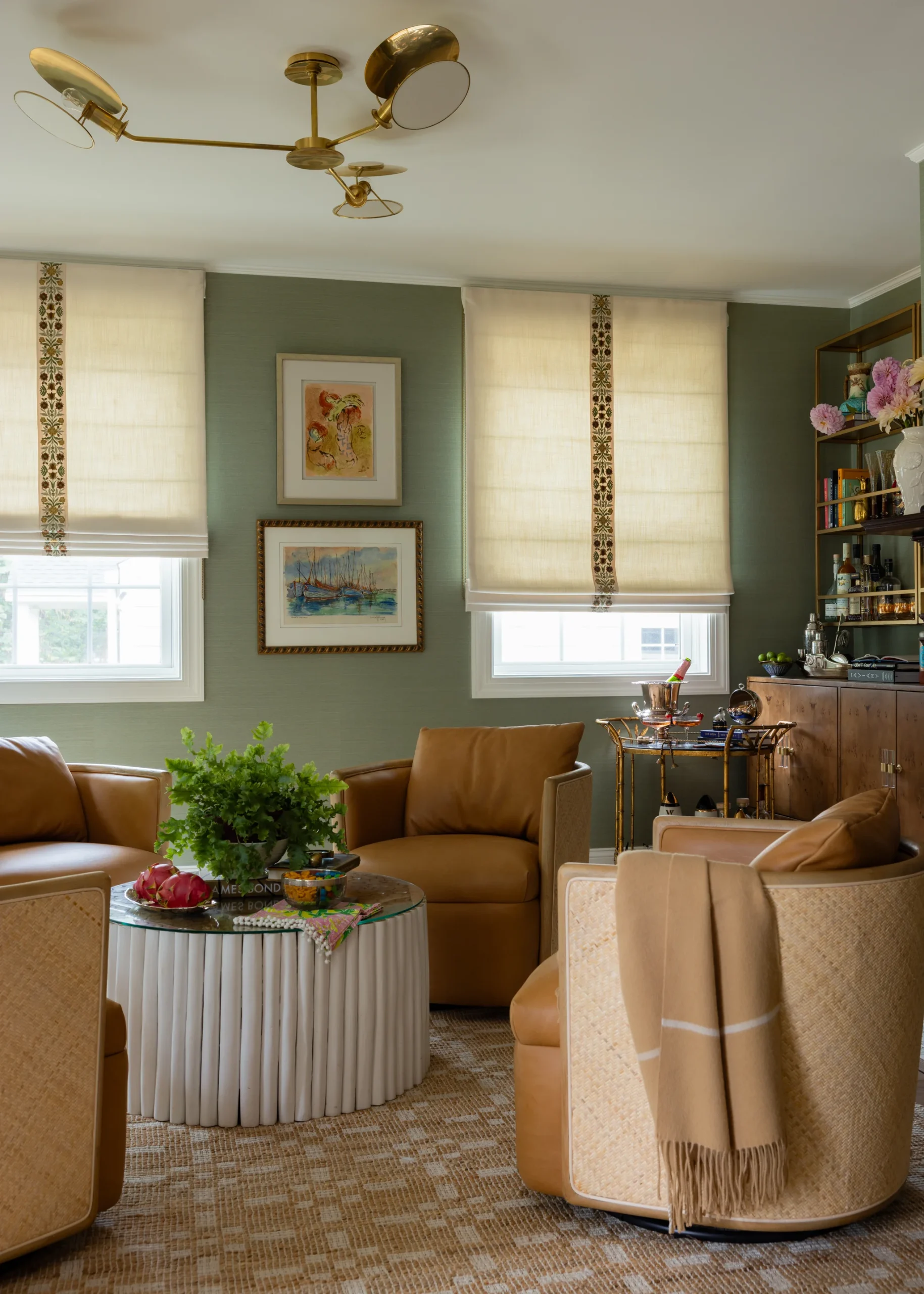 Whole-home remodel in Sedgefield, living room with green walls, leather chairs, and a bar cart