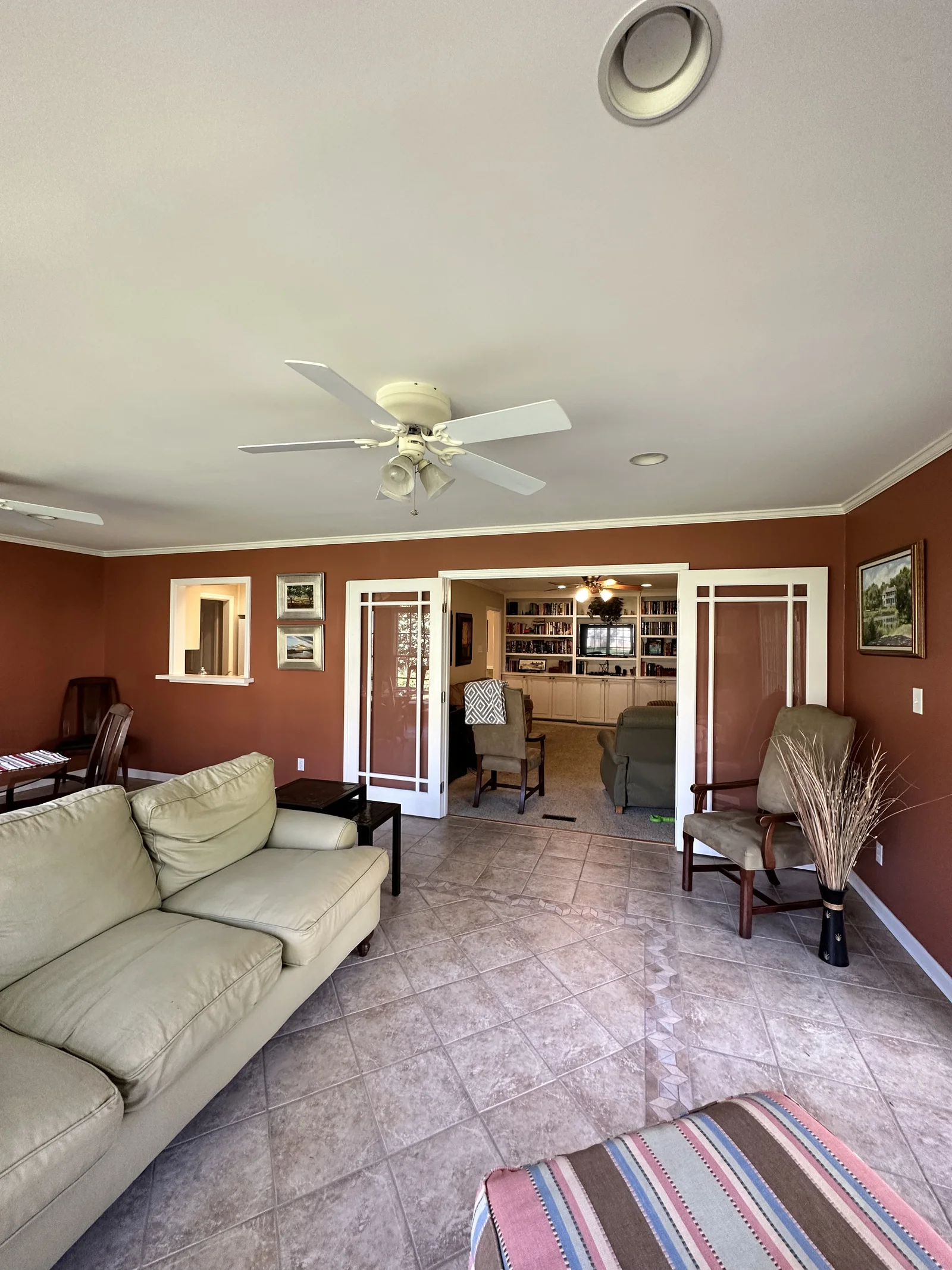 First-floor remodel in Old Georgetown, living room with red walls, tile floor, and ceiling fans
