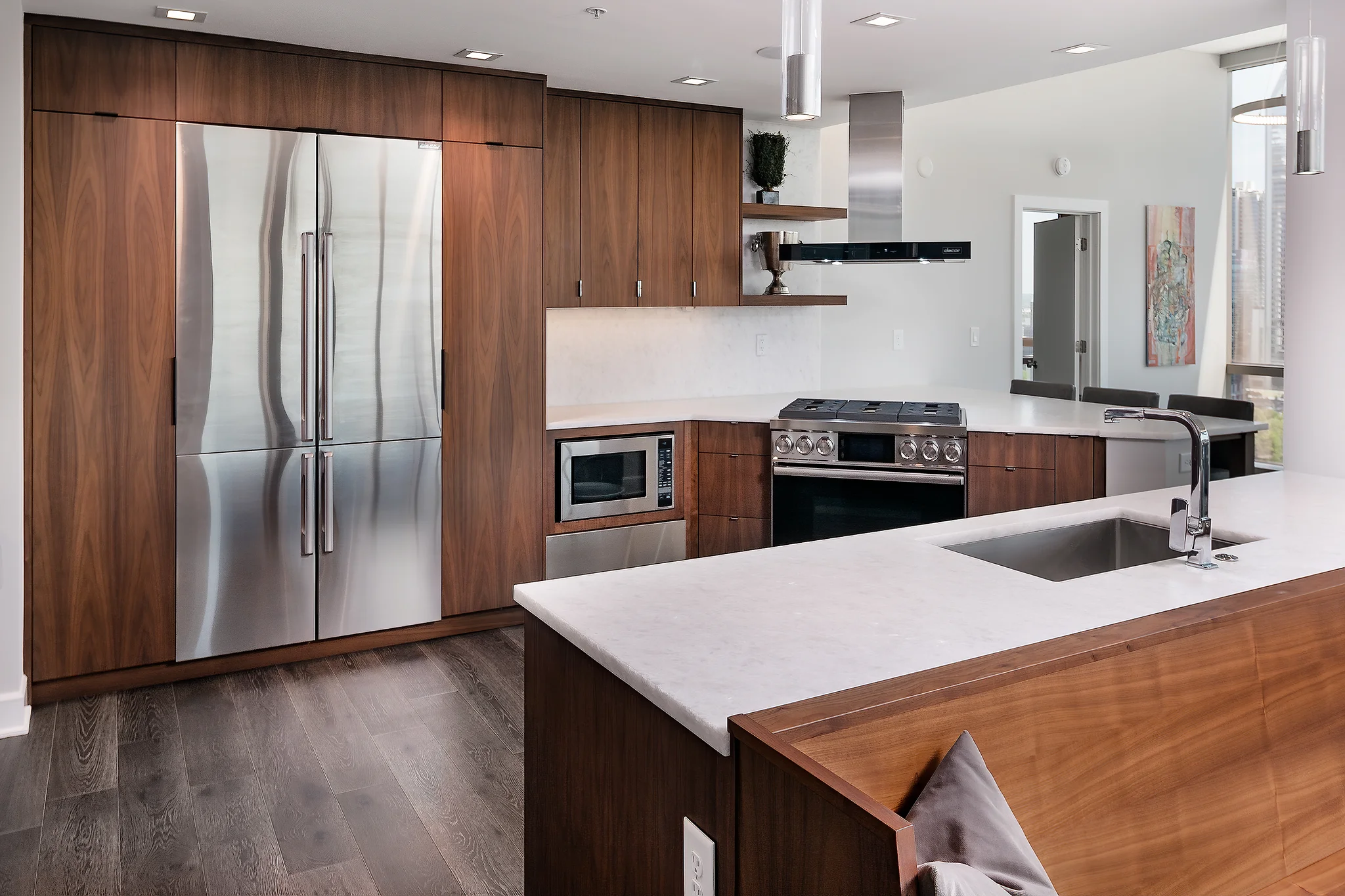After: Penthouse kitchen at The Arlington with walnut cabinets, stainless appliances, and white quartz countertops
