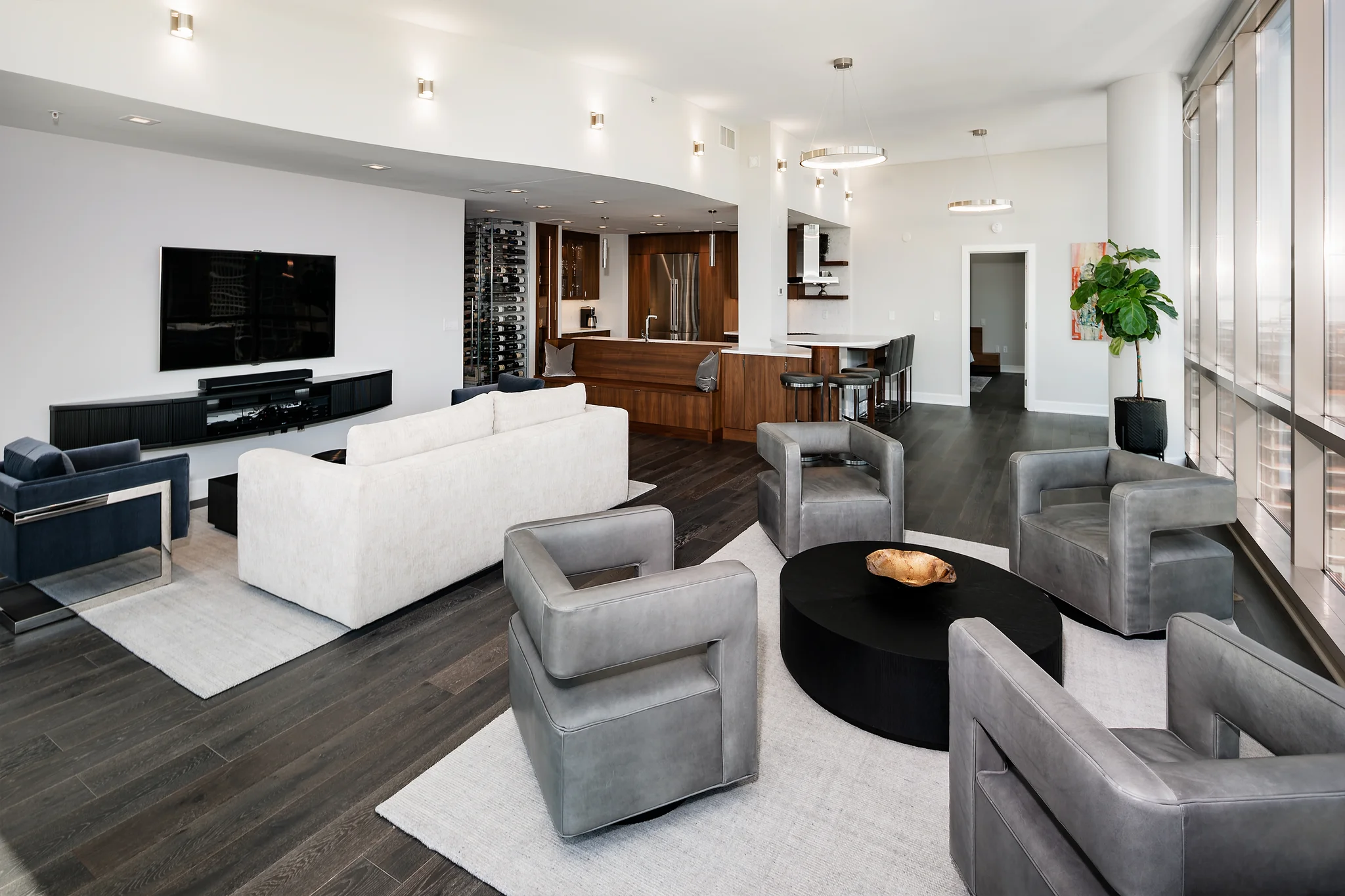 Open-concept living room with dark wood floors, white walls, and gray armchairs, Charlotte, NC