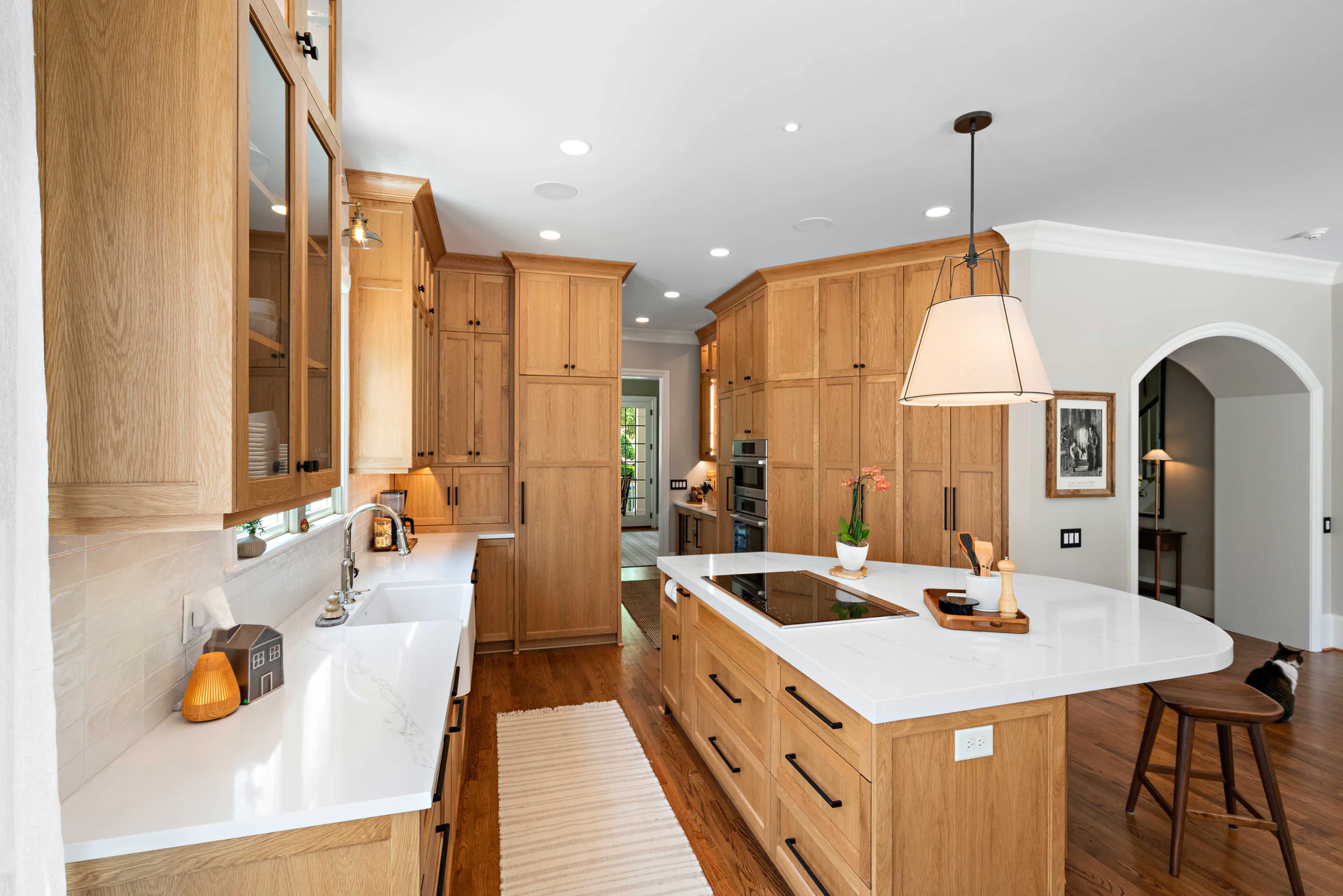 Kitchen remodel in Heydon Hall with natural oak cabinets, white quartz countertops, and a large island