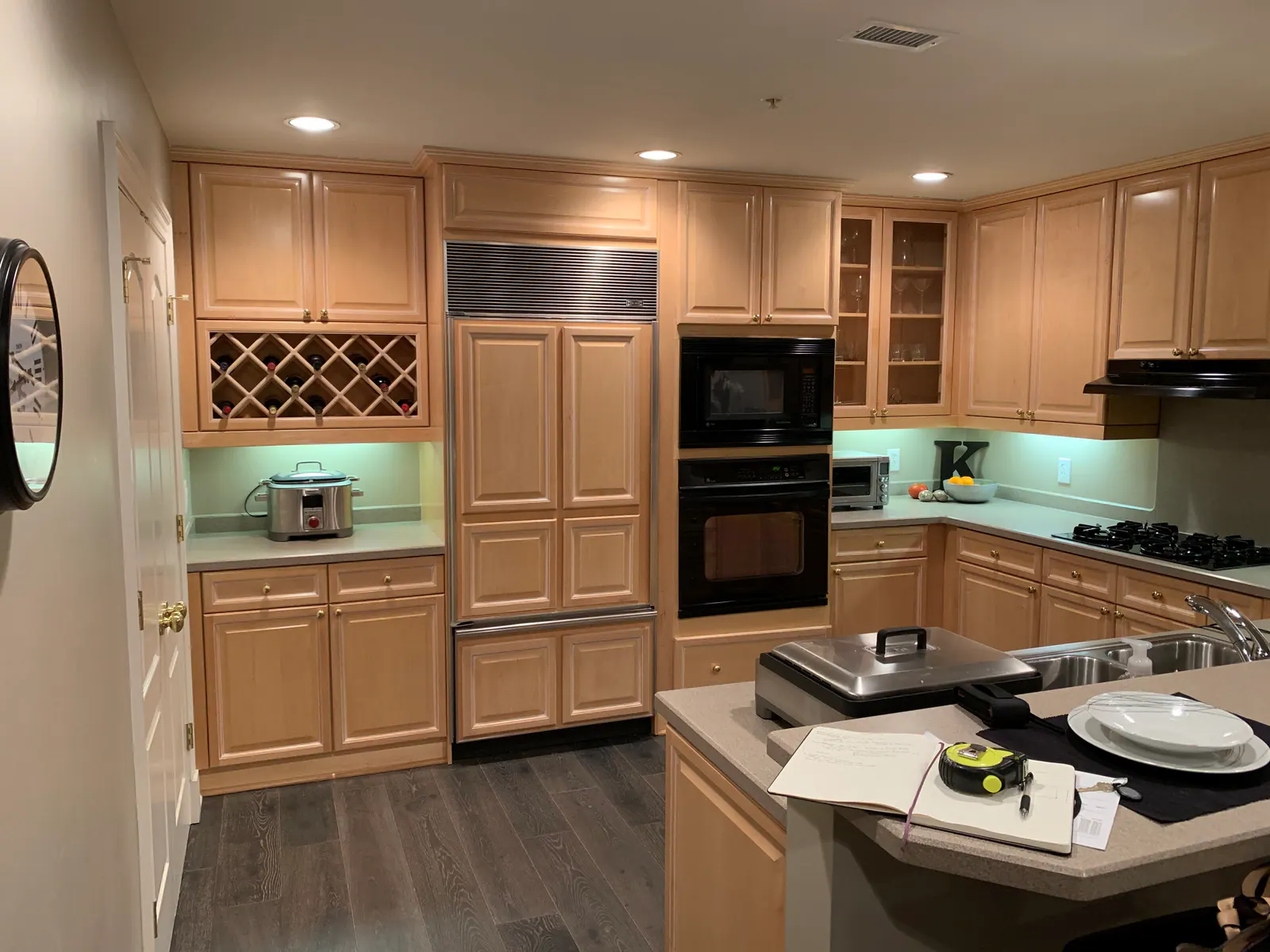Before: Penthouse kitchen at The Arlington with light wood cabinets, a built-in refrigerator, and a gas range