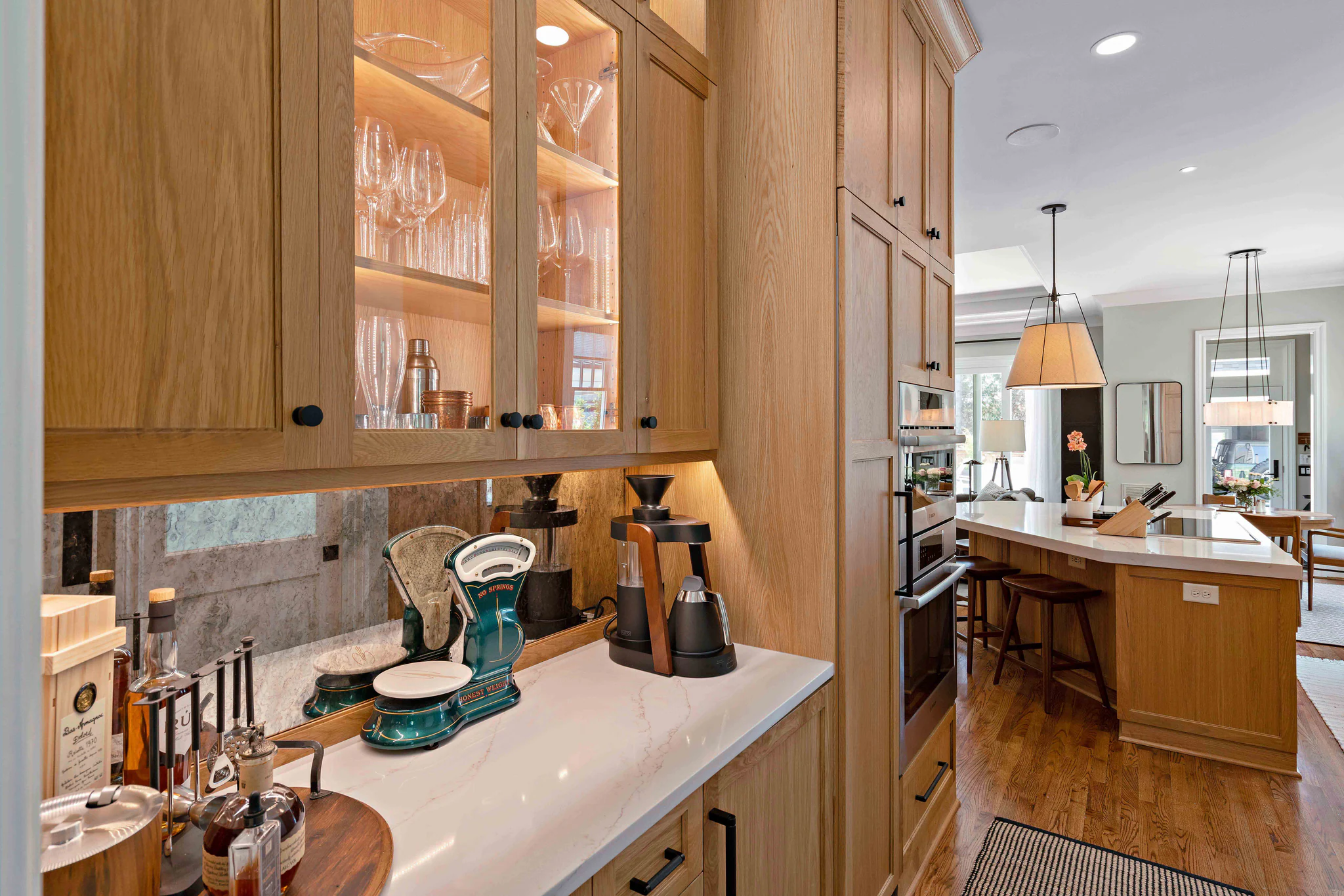 Kitchen remodel in Heydon Hall with light oak cabinets, a mirrored backsplash, and a large island