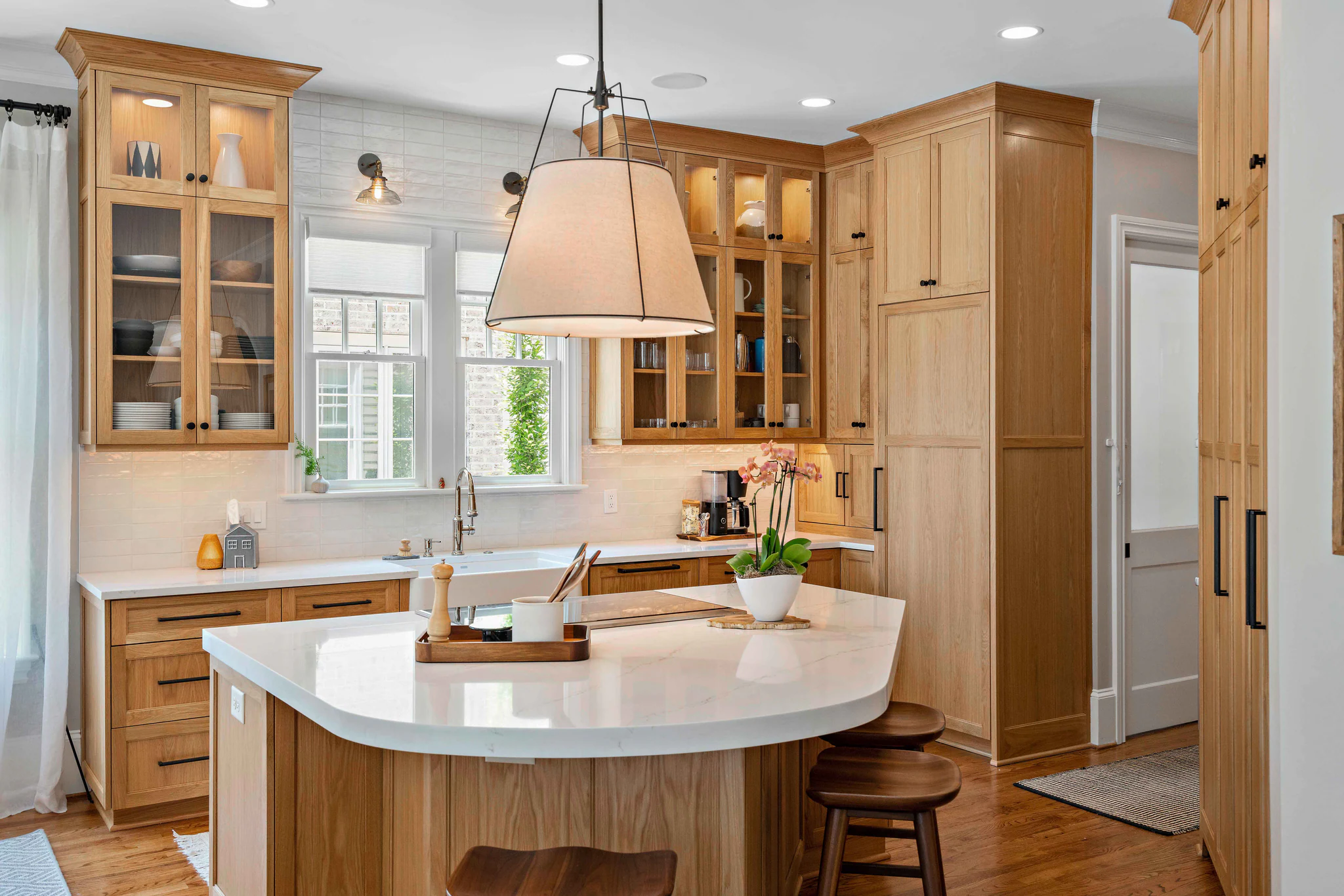 After: Heydon Hall kitchen with light oak cabinets, a white quartz island, and a subway tile backsplash