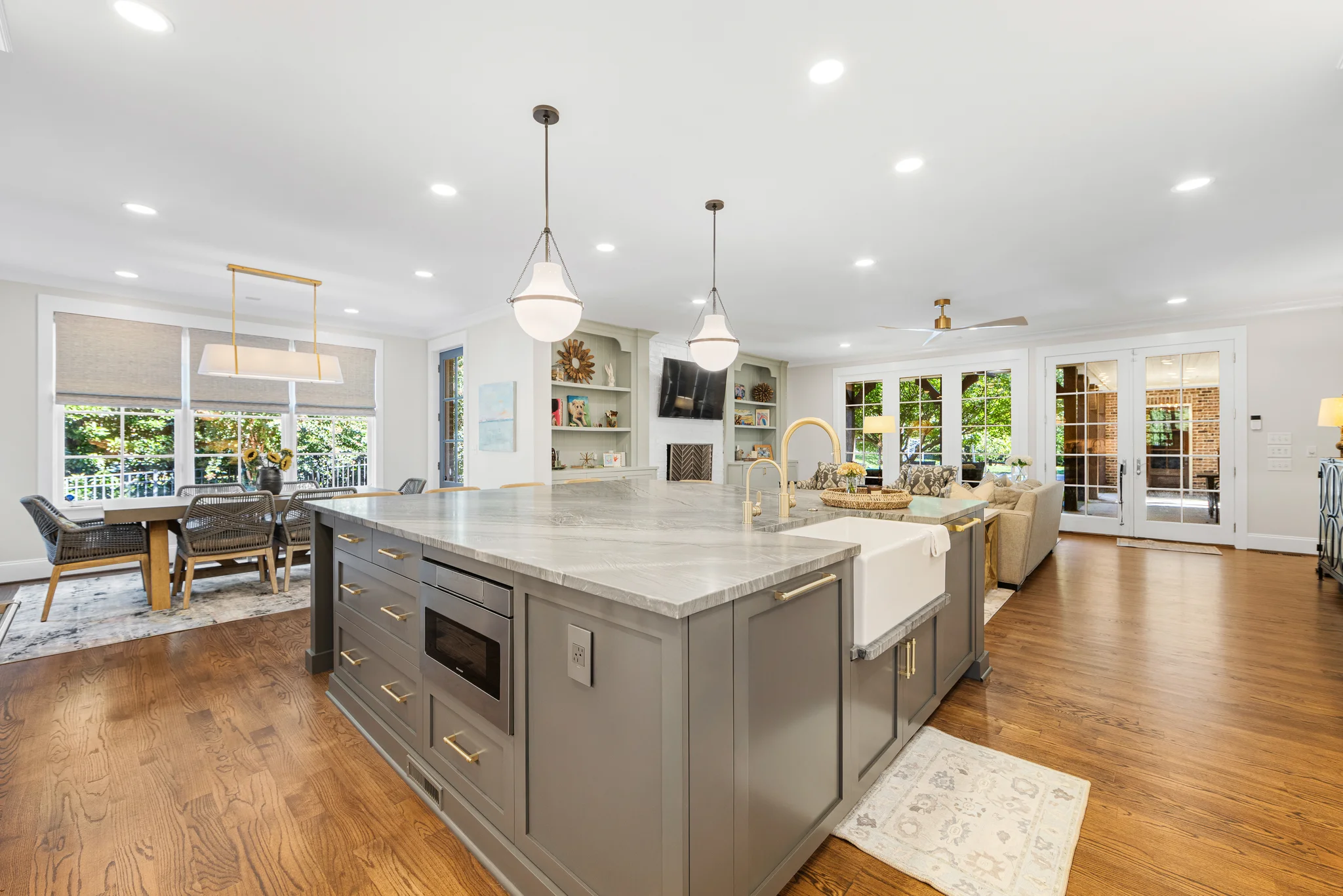 Open concept first-floor remodel in Charlotte, kitchen island with farmhouse sink, dining area, living room