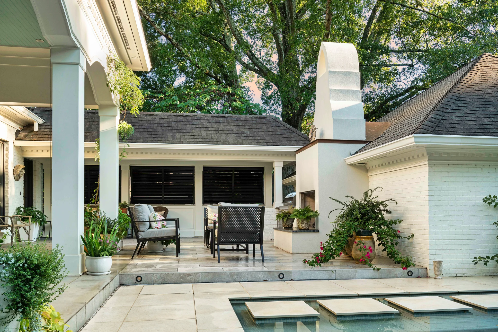 After: Morrocroft backyard with a patio, a fireplace, and a pool with stepping stones