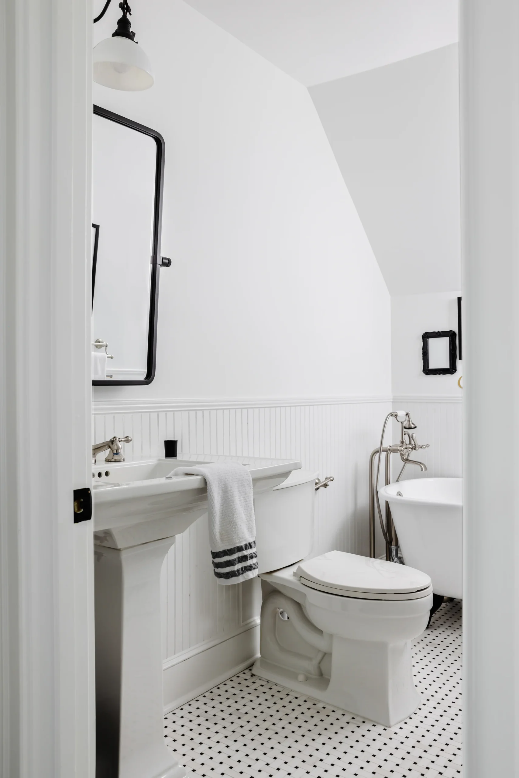 After: White Quail Hollow bathroom with a pedestal sink, beadboard, and a clawfoot tub