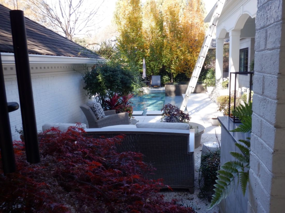 Outdoor renovation in Morrocroft with a pool, patio, and white brick wall