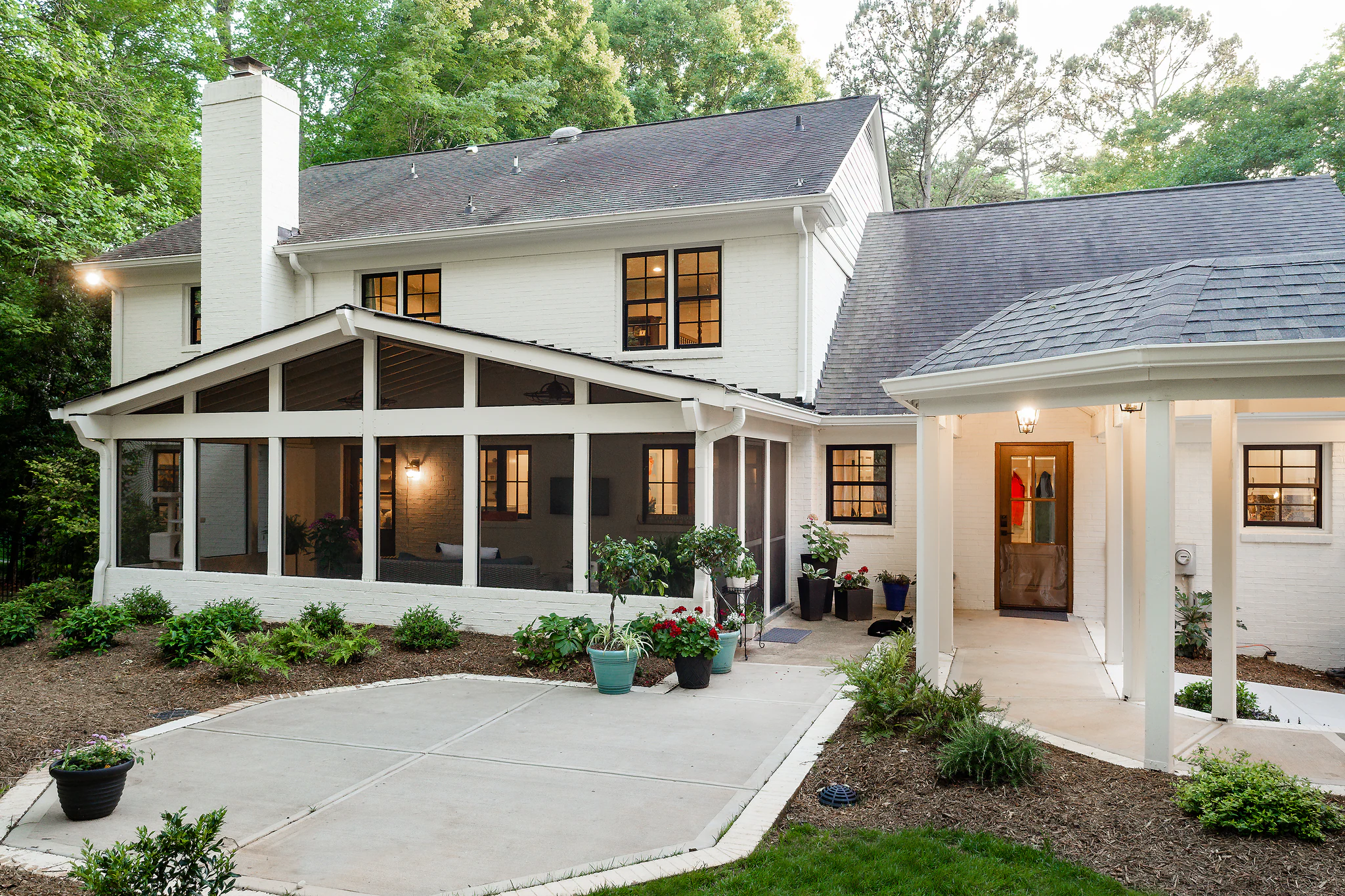 After: Providence Plantation home with a white brick exterior, a screened porch, and a concrete patio