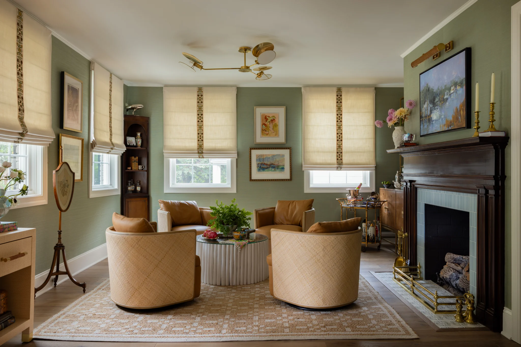 After: Sedgefield living room with green walls, a fireplace, and light wood furniture
