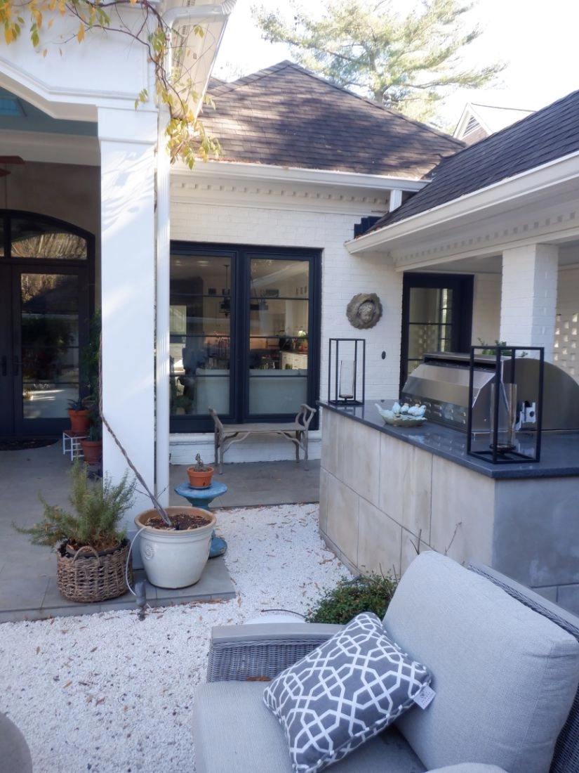 Outdoor renovation in Morrocroft with white brick, black-framed doors, and a built-in grill station