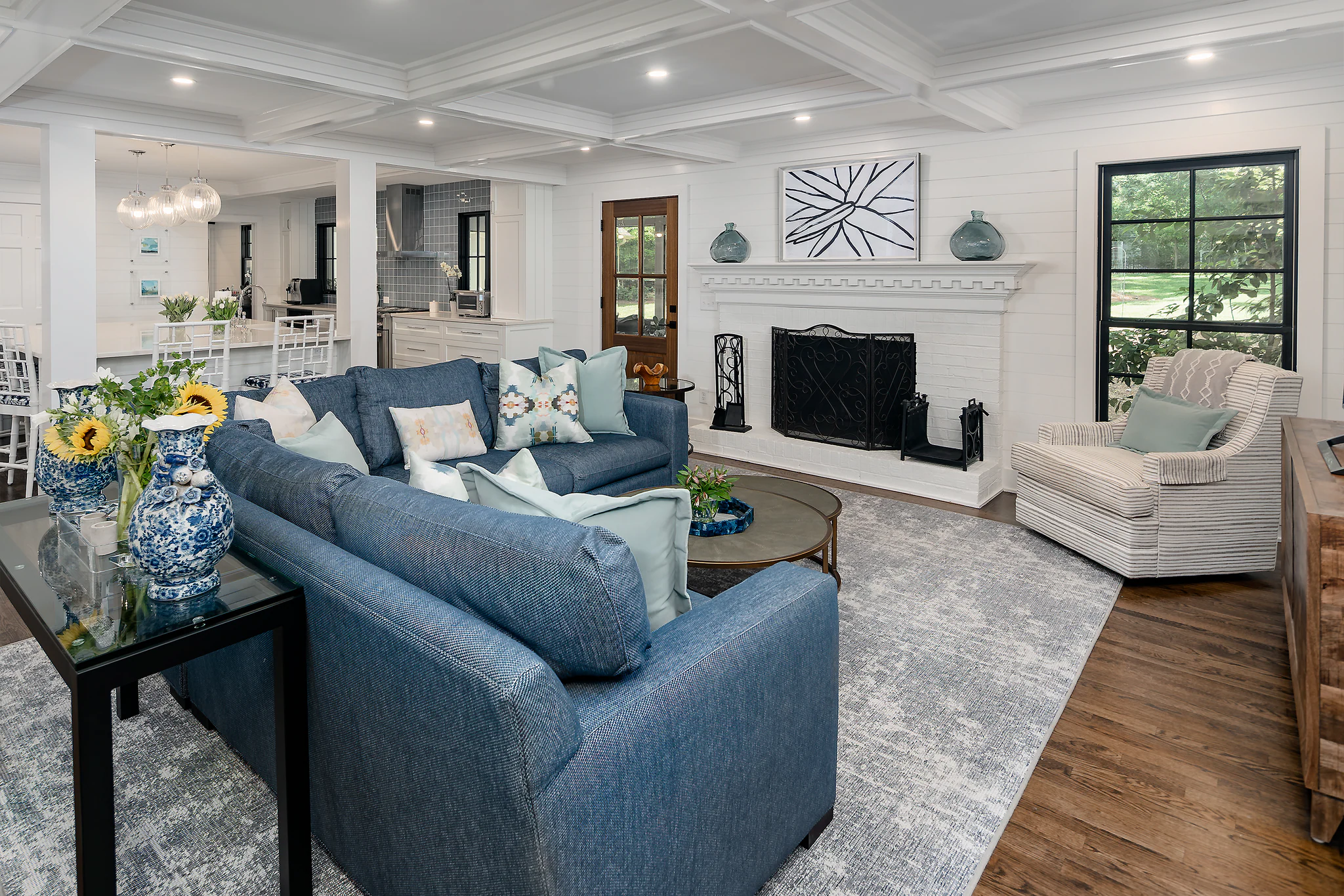 Whole-home remodel in Providence Plantation, living room with blue sofa, white fireplace, and coffered ceiling