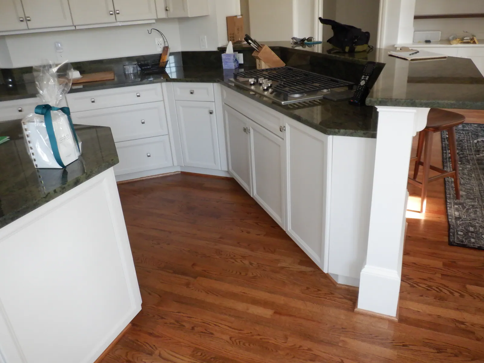 Kitchen remodel in Heydon Hall with white cabinets, dark granite countertops, and hardwood floors