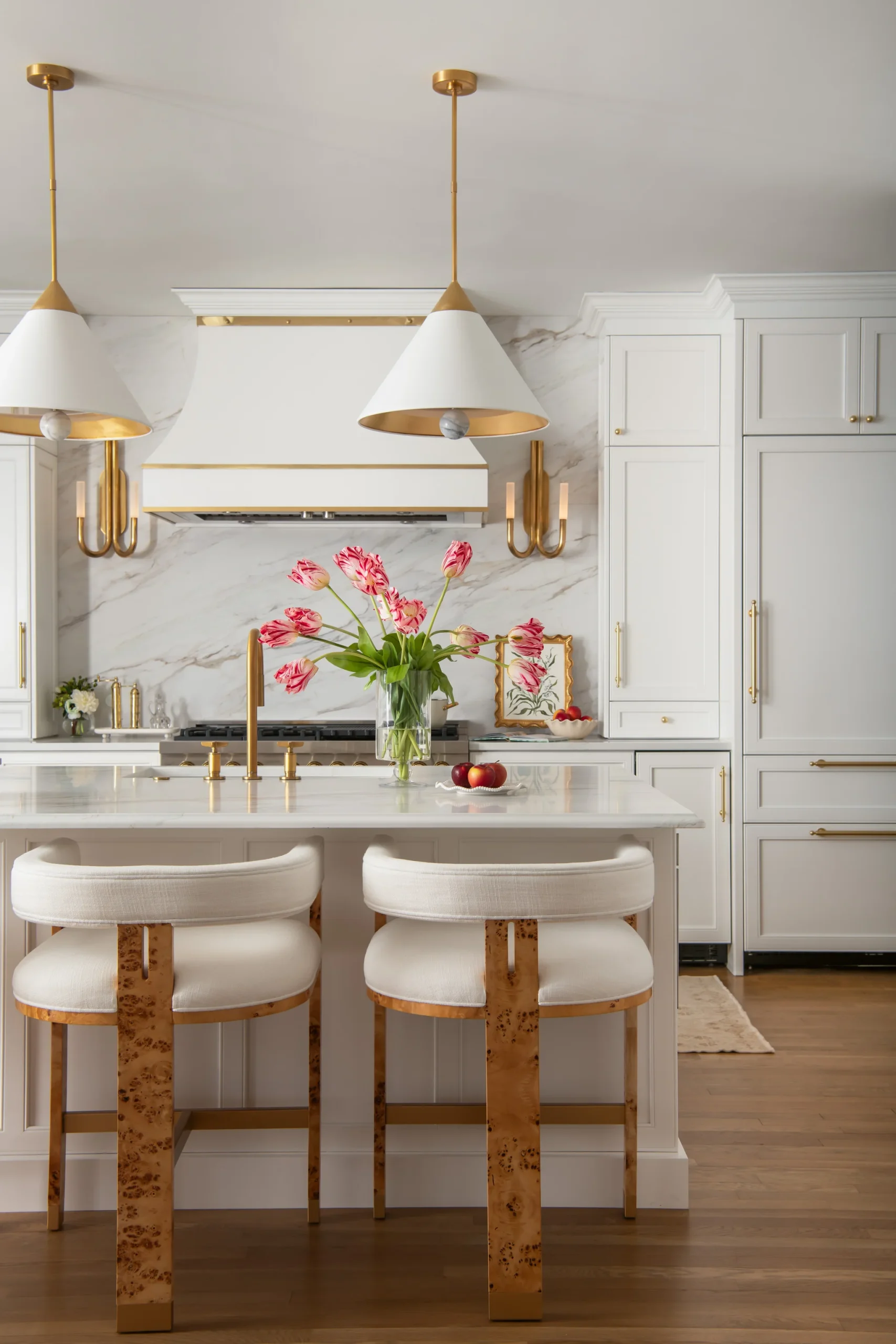 Kitchen remodel in Ballantyne Country Club with white cabinets, gold hardware, and a marble island