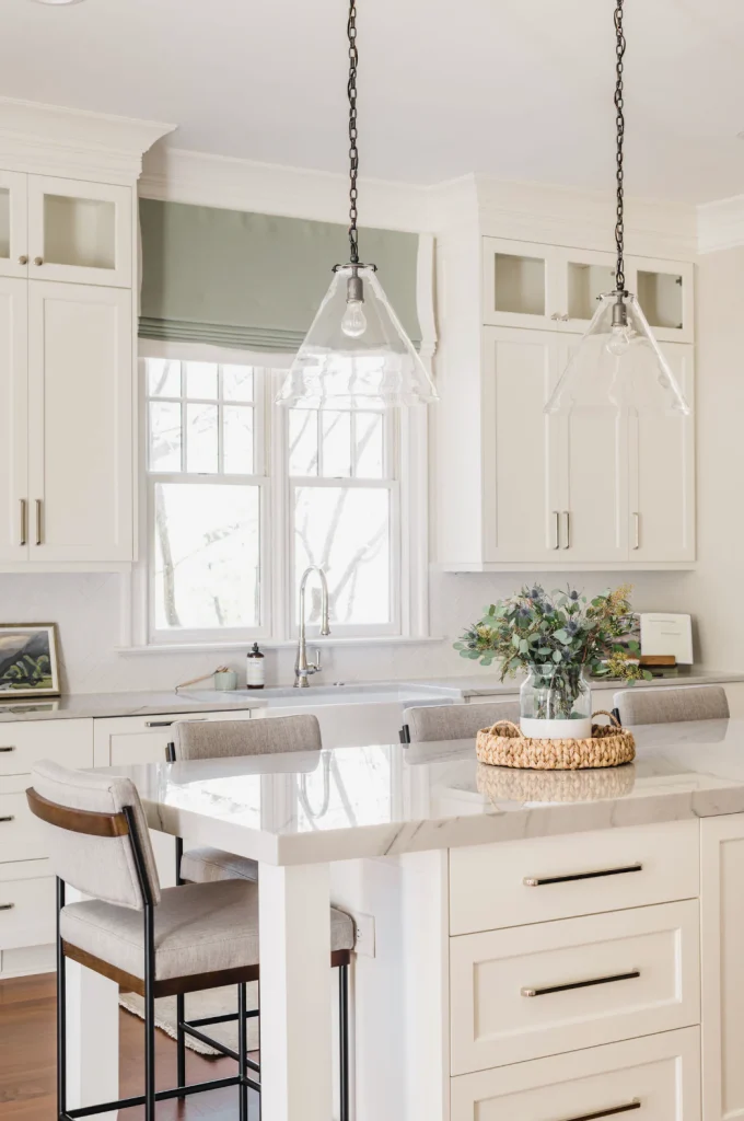 Kitchen remodel in Ballantyne Country Club with white cabinets, a large island, and pendant lights