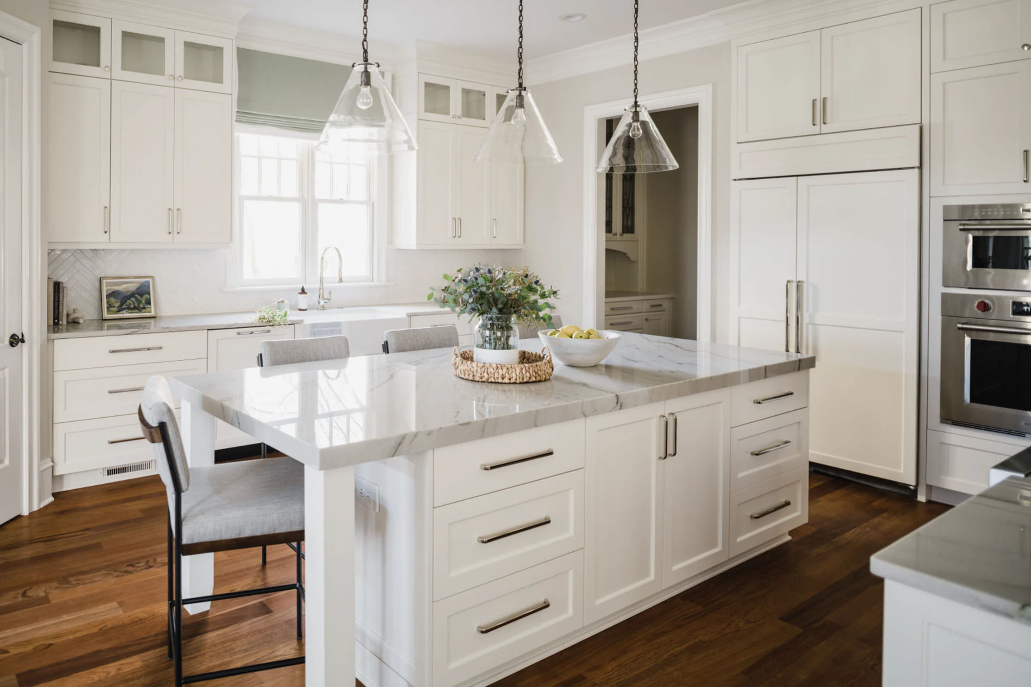 Whole-home remodel in Ballantyne Country Club, white kitchen with a large island, quartz countertops