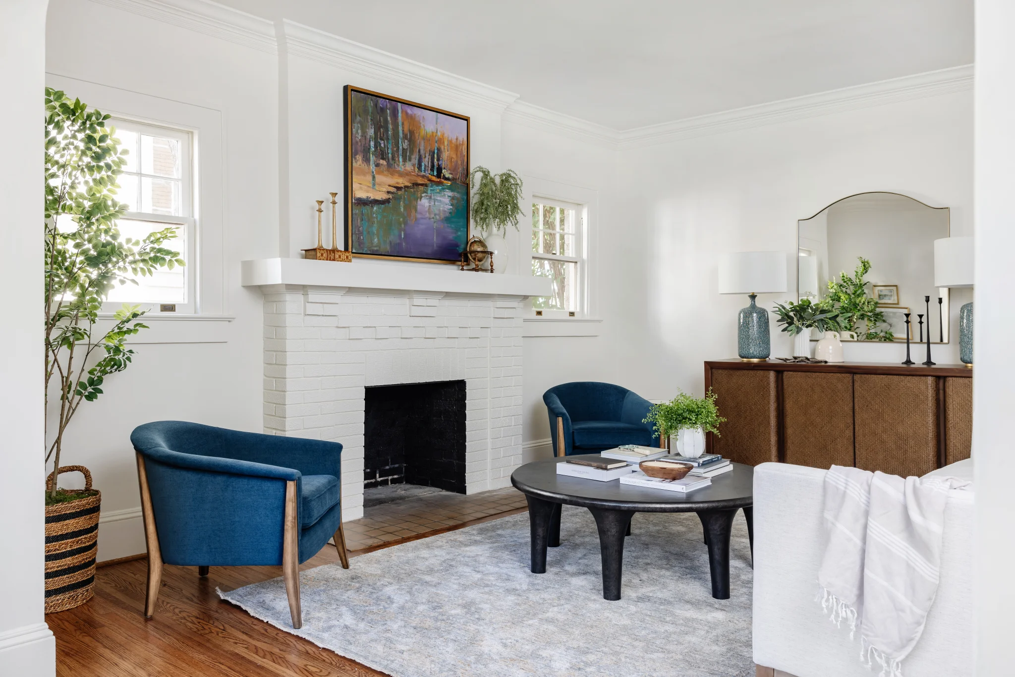 Whole-home remodel in Historic Dilworth, living room with white fireplace, blue chairs, and wood console