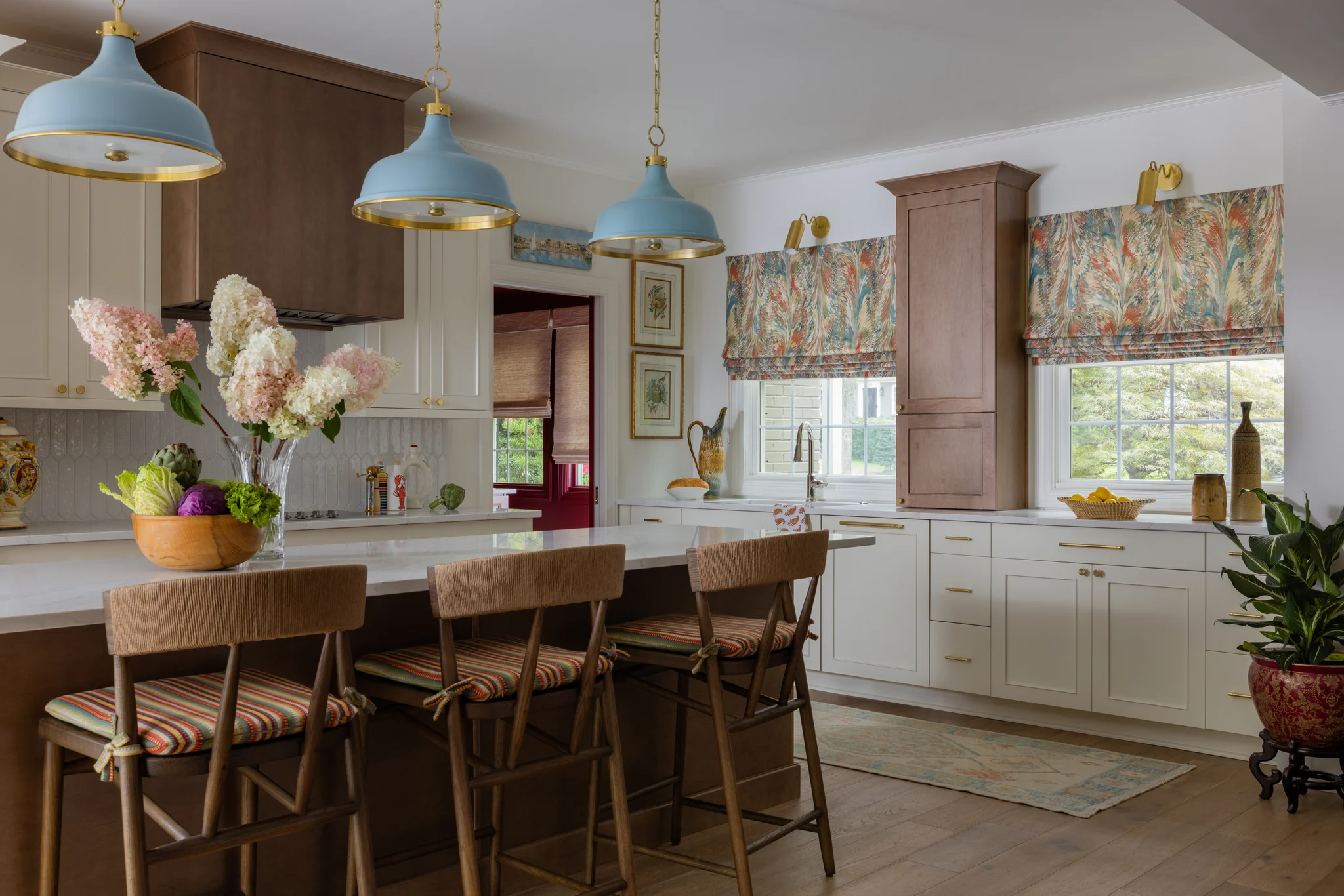 Whole-home remodel in Sedgefield, kitchen with light blue pendant lights, wood island, and white cabinets