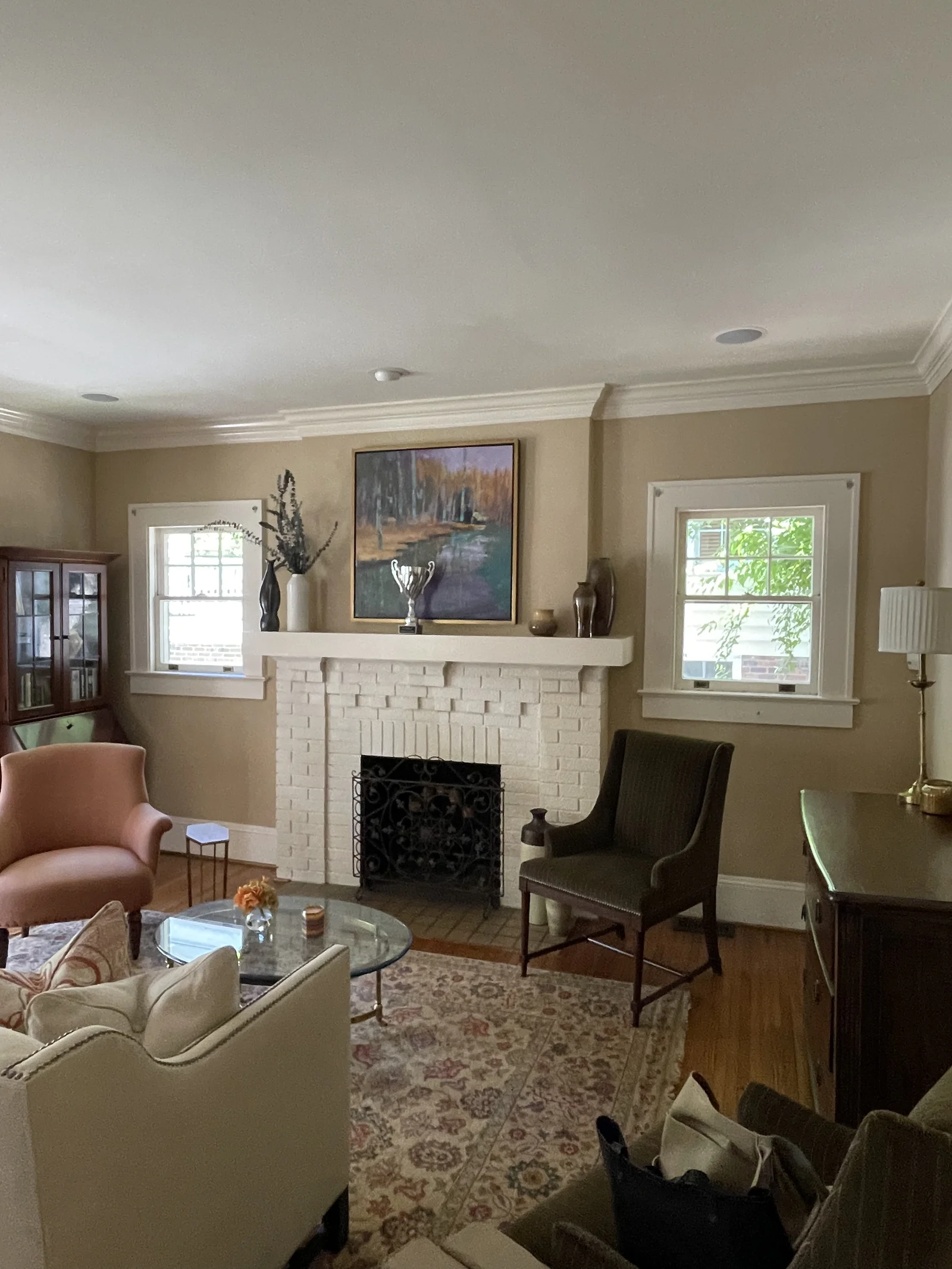 Before: Dilworth living room with beige walls, a white brick fireplace, and a patterned rug