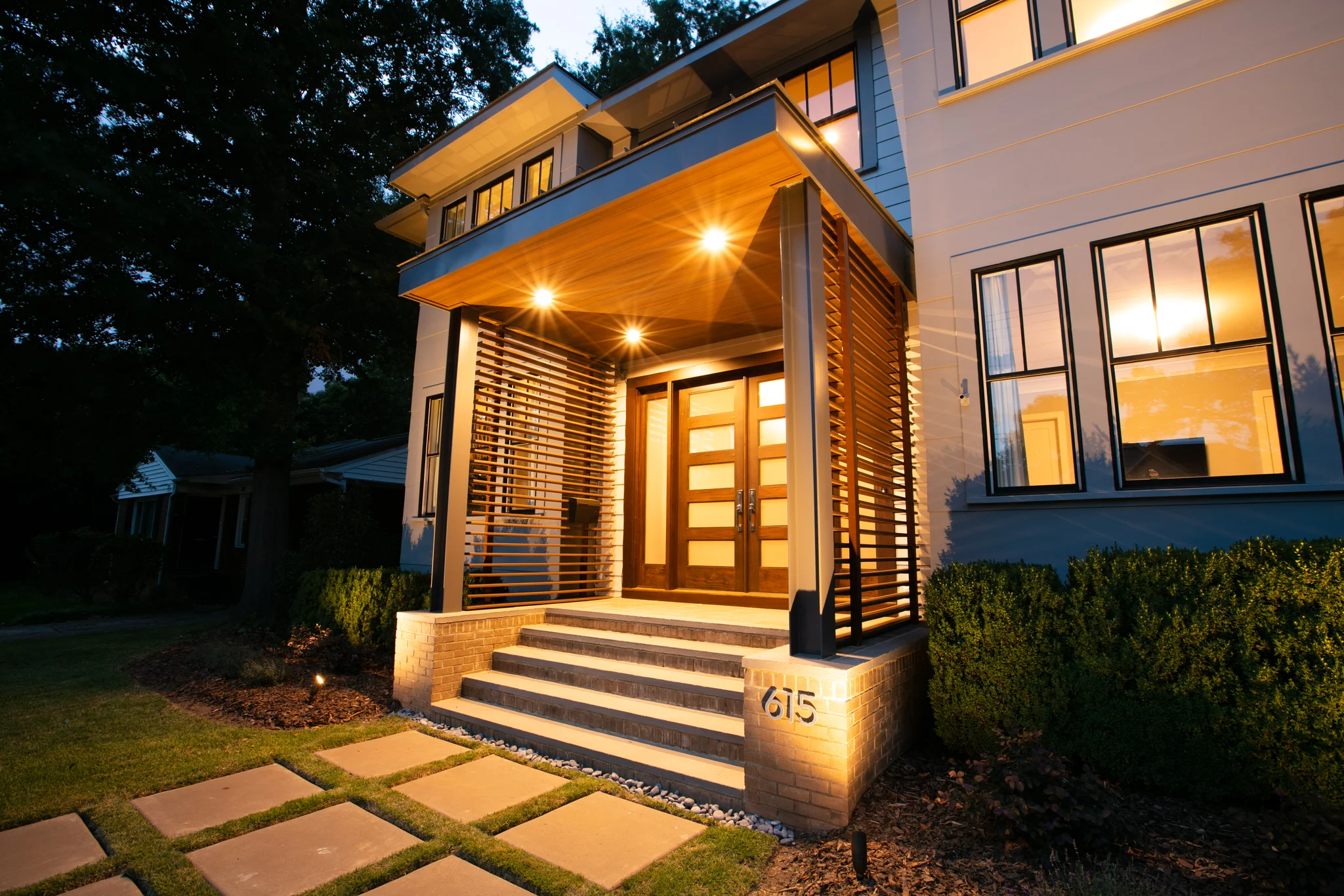 Porch addition in Charlotte, NC, with wood ceiling, recessed lighting, and modern front door