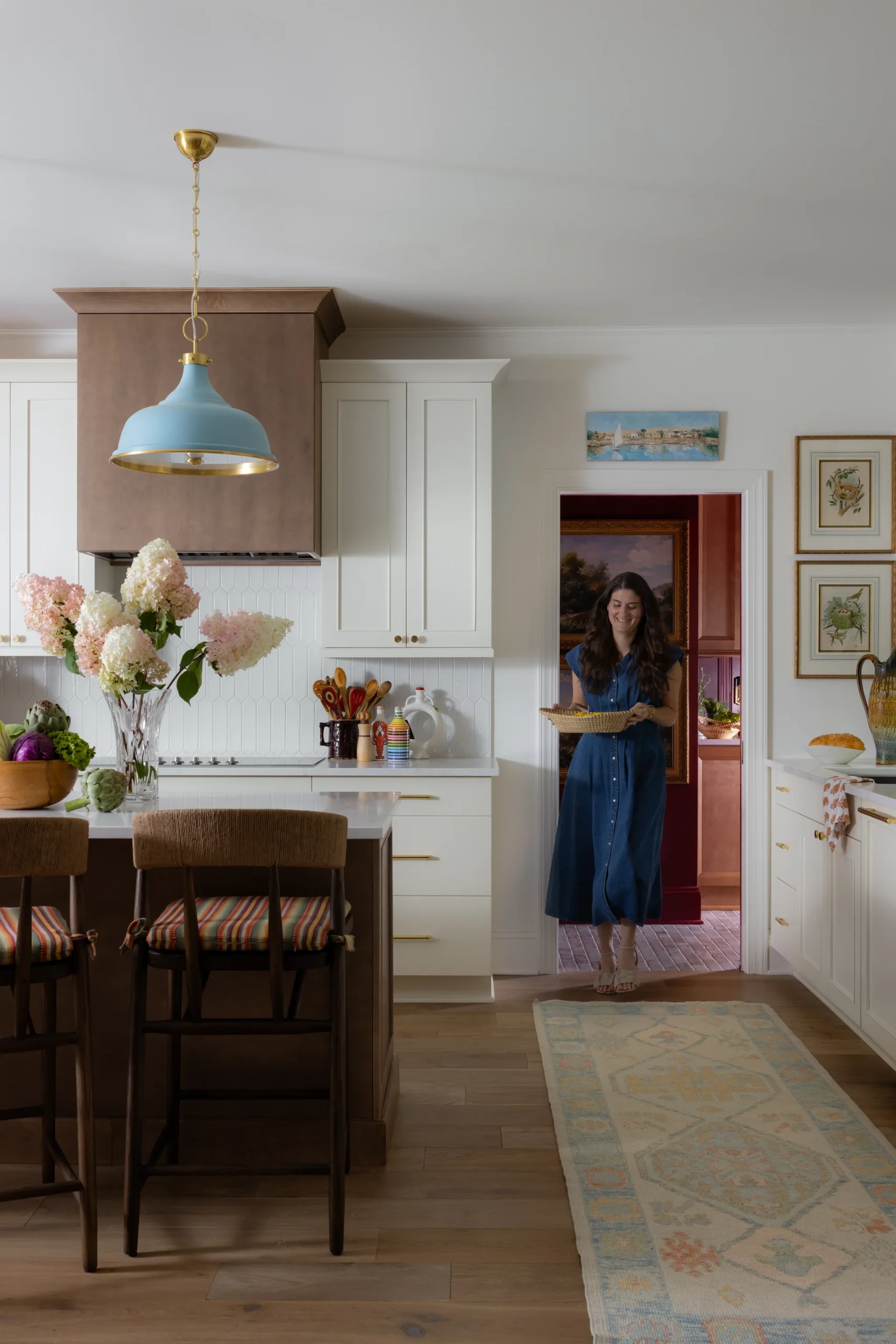 Whole-home remodel in Sedgefield, kitchen with white cabinets, wood island, and blue pendant light
